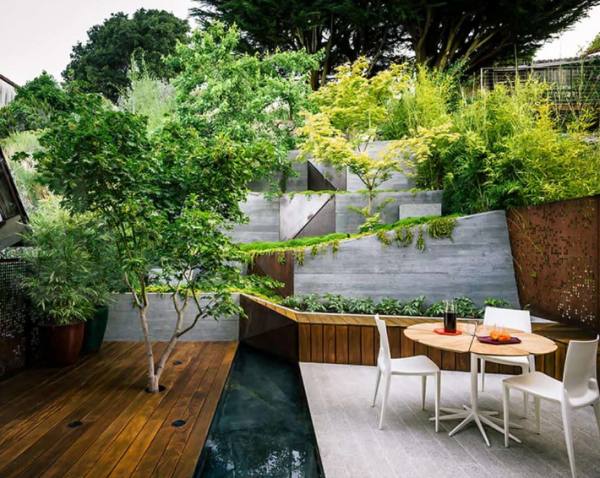 Teras dengan dek kayu dan taman vertikal dengan tanaman hijau